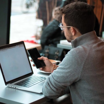Symbolbild eines jungen Mannes mit Laptop auf der Suche nach Informationen